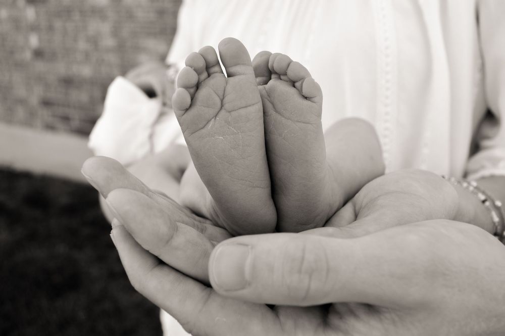 Baby feet being held by parents