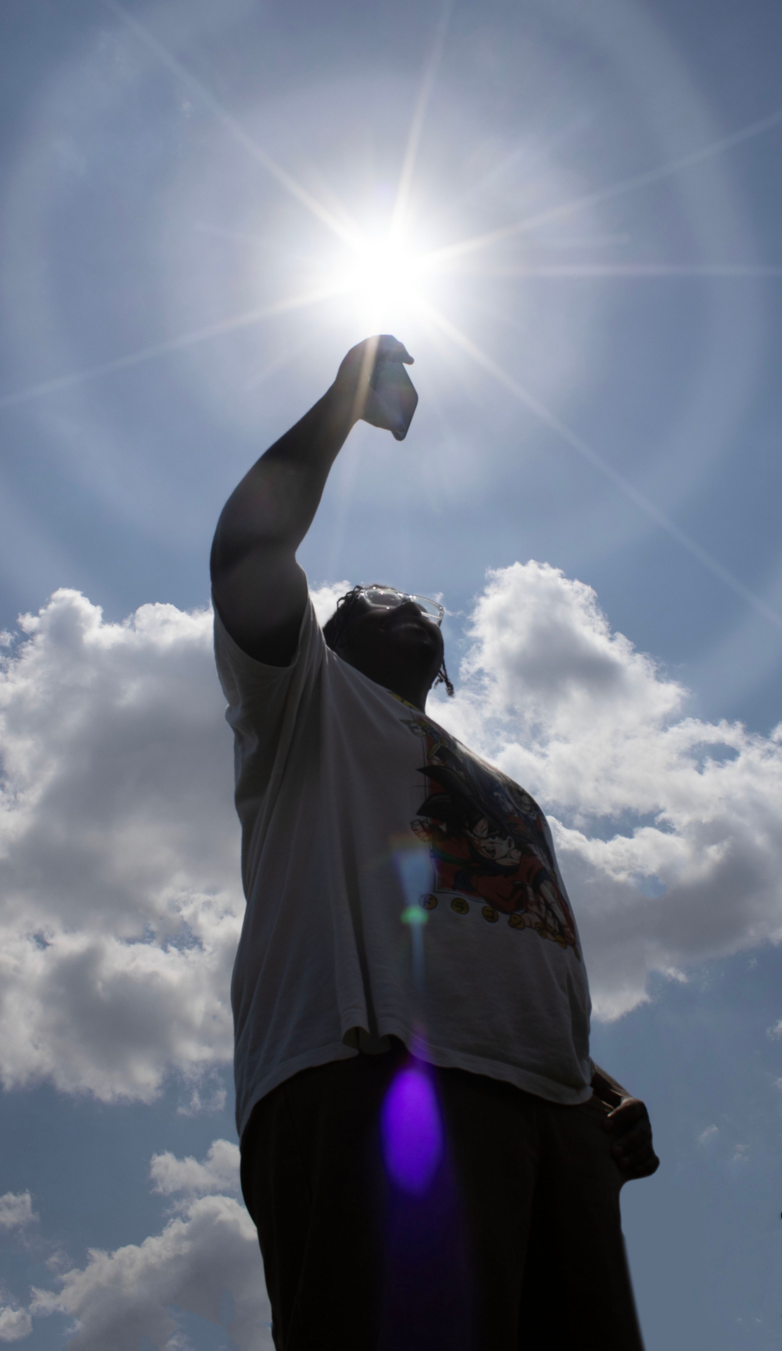 An individual lining up his hand with the sun.