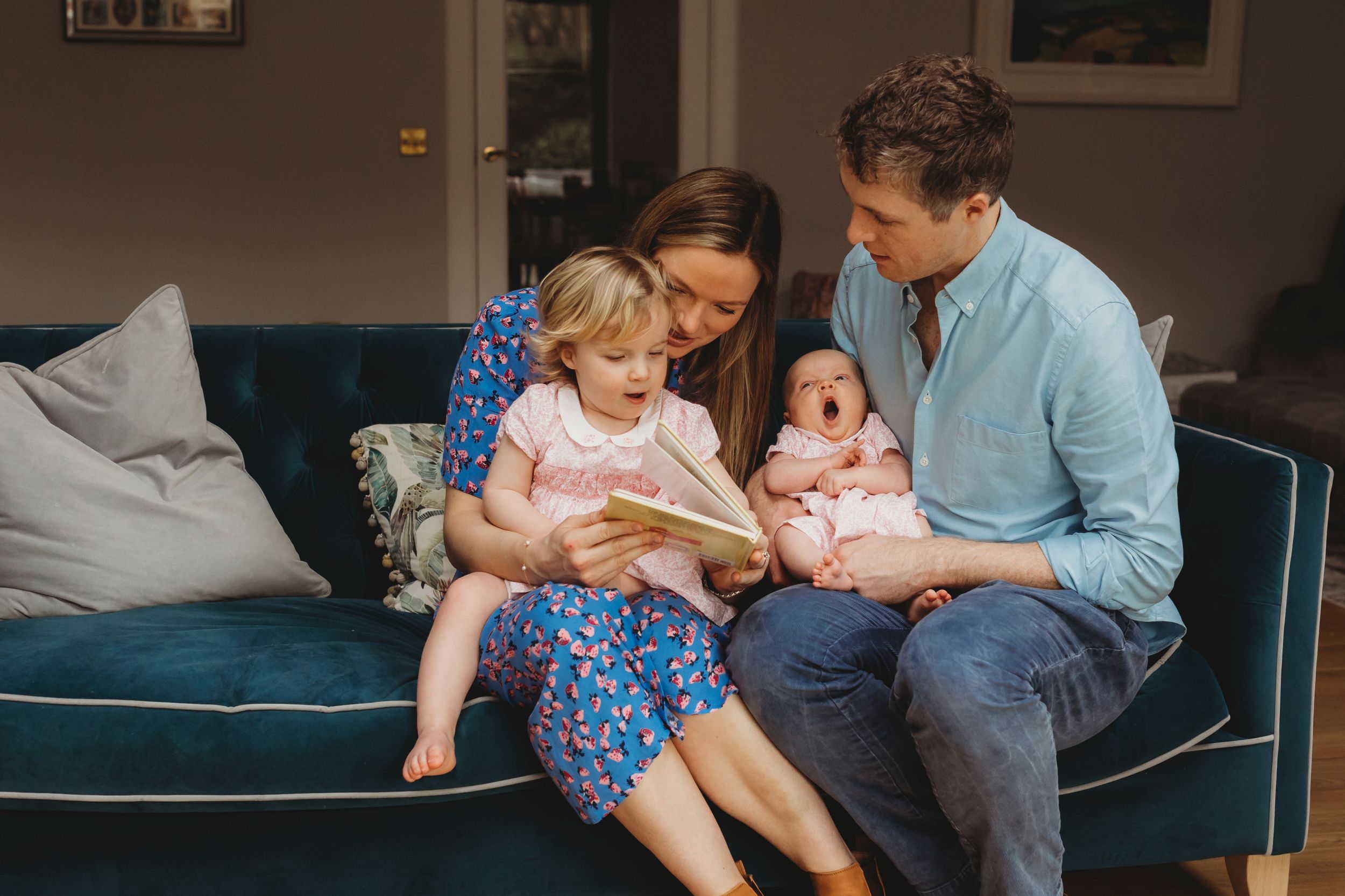 Family sharing intimate moment together on blue sofa at home.
