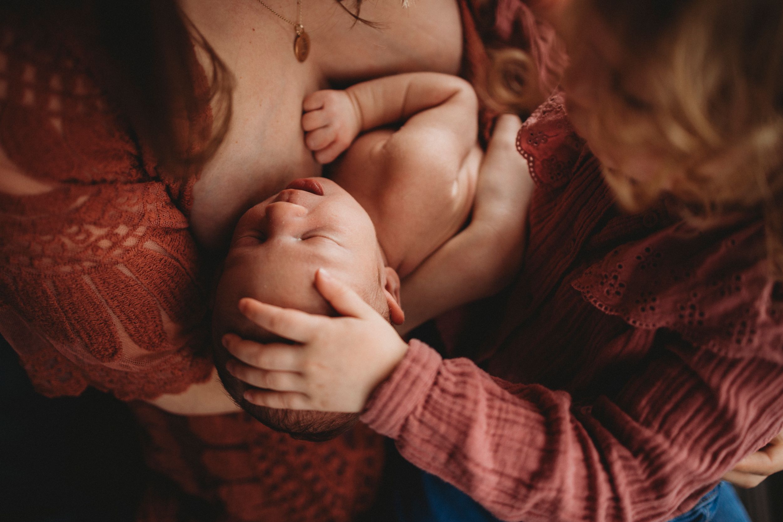 Intimate family moment captured in warm tones as parents embrace young child.