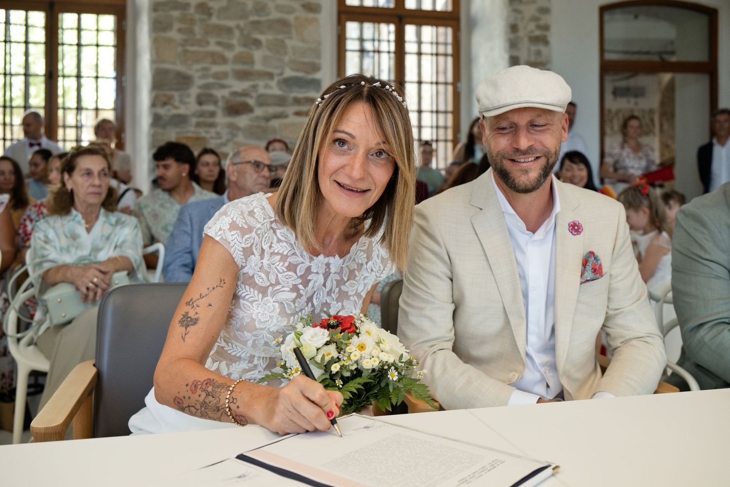 Delphine signe le registre de mariage à Peynier, avec Christophe souriant à ses côtés.