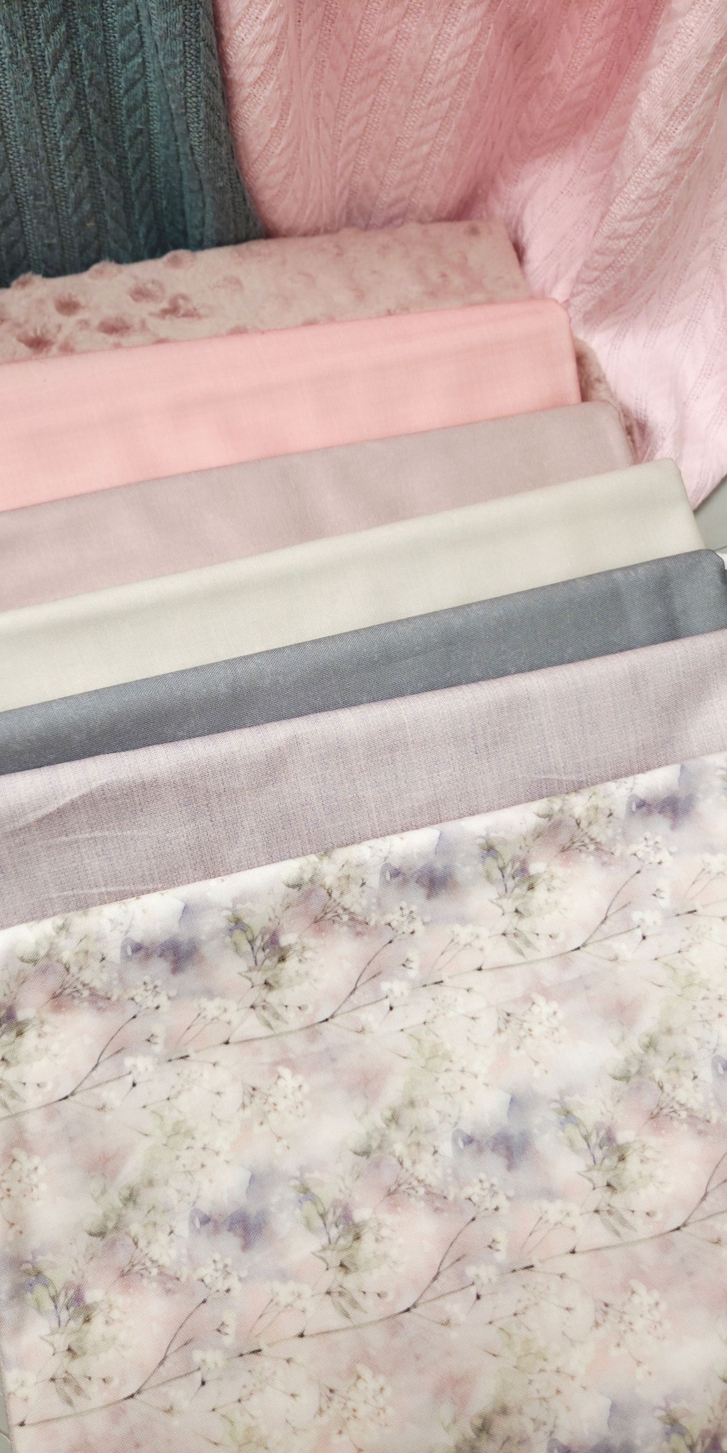 Stacked fabric swatches in pink, cream, gray, and lavender with a soft floral print on white base.