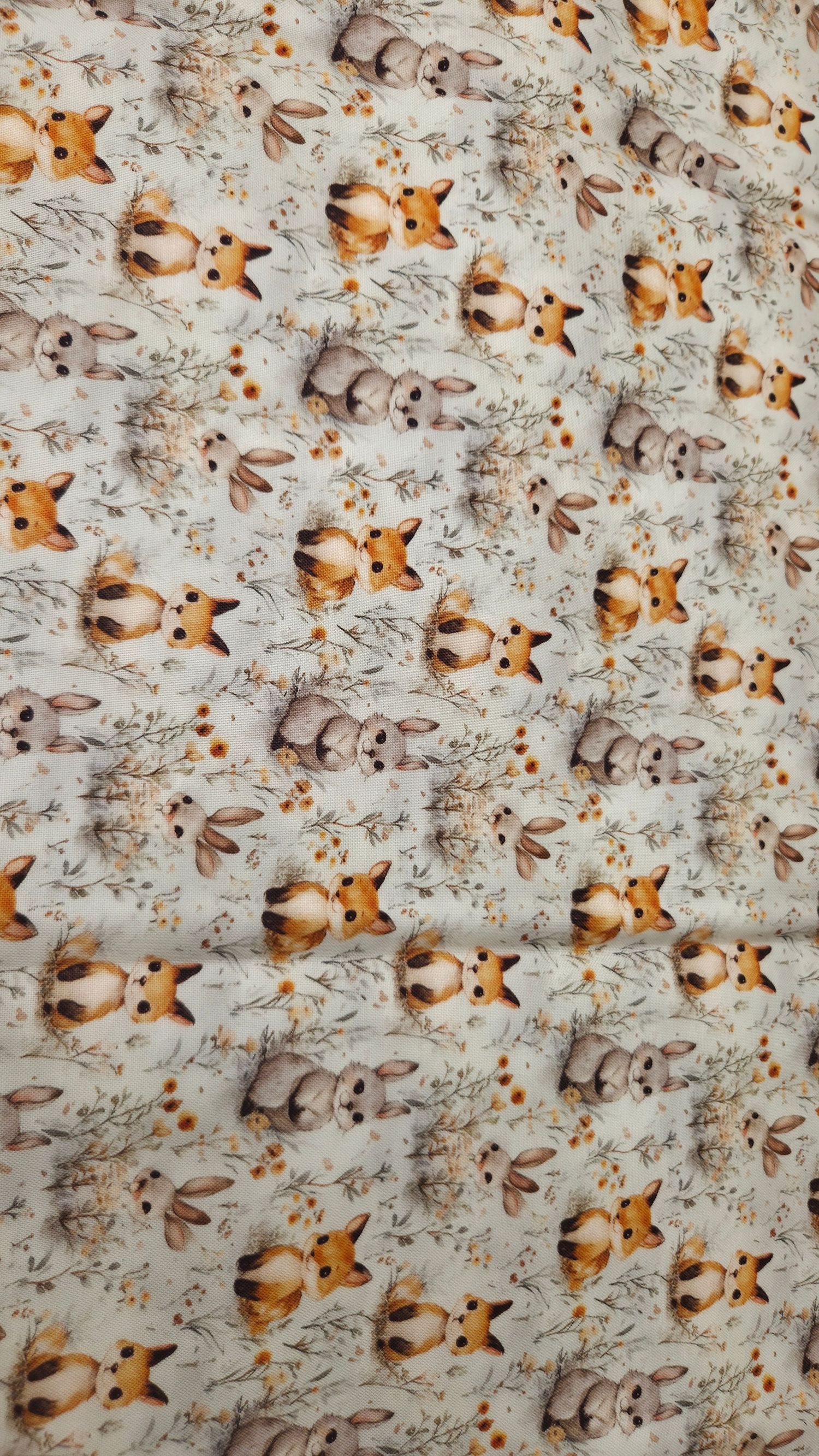 Cute woodland animals fabric print featuring foxes, rabbits, and floral sprigs on a cream background.