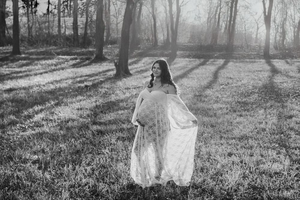a beautiful pregnant mother during a maternity session in a wooded area in Manila Arkansas