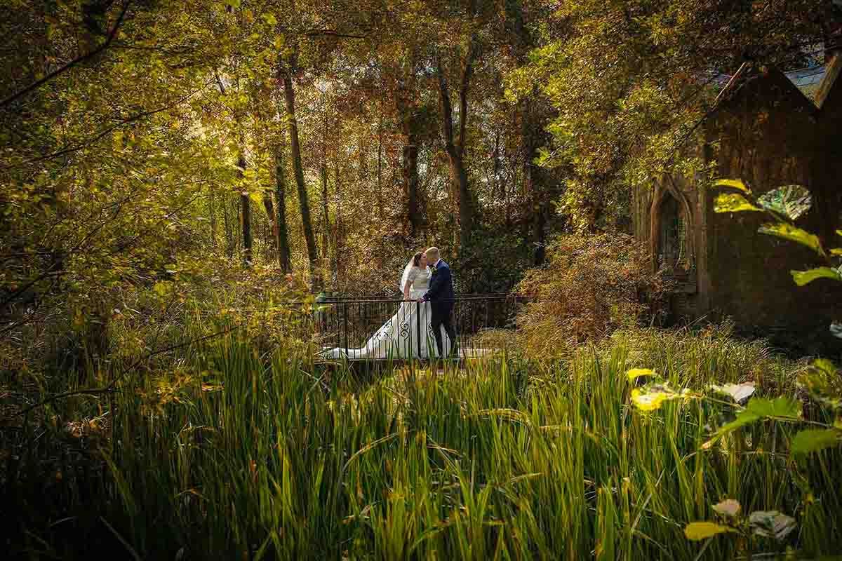 Bride and groom embracing on a bridge at Blaithwaite House a premier Cumbrian wedding venue