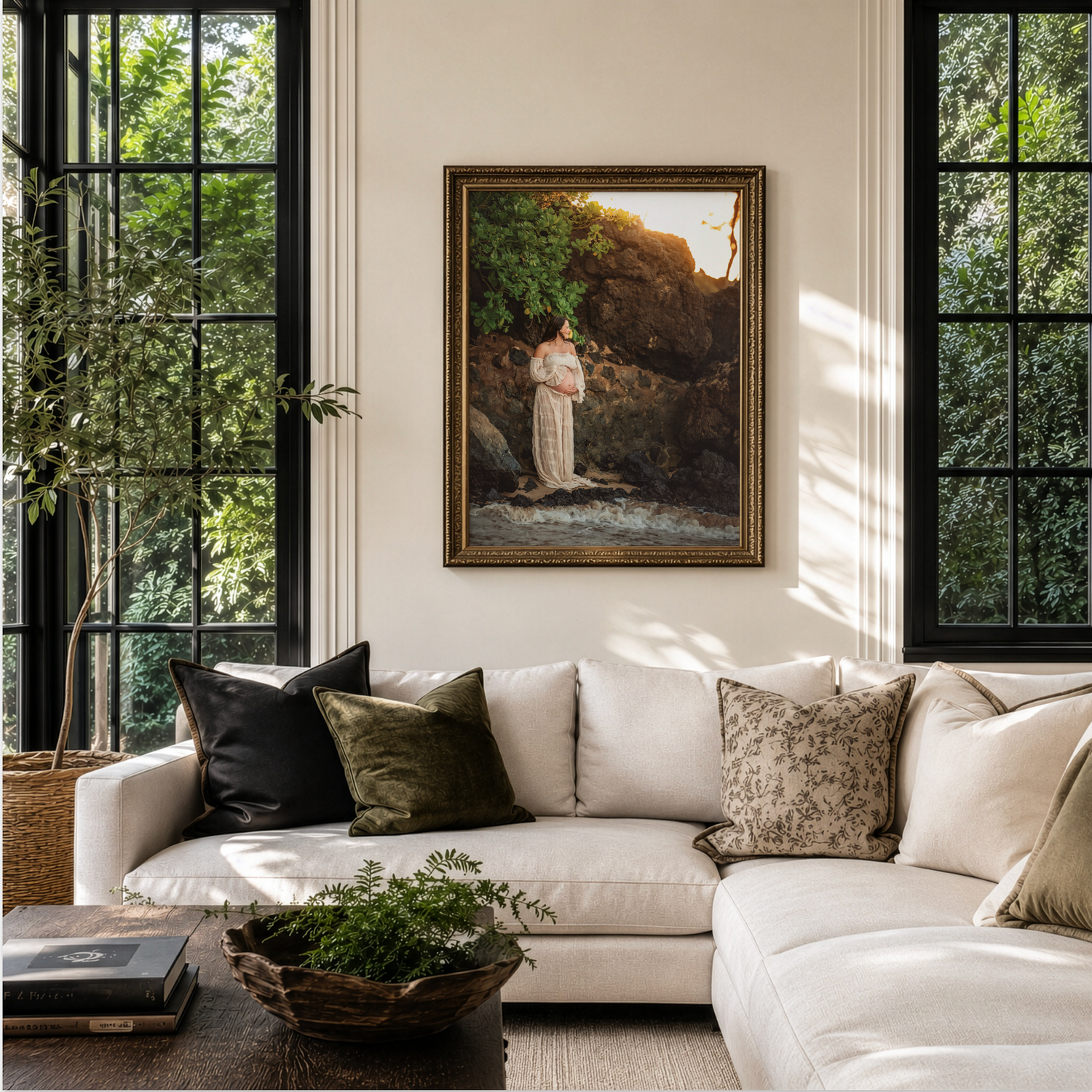 Elegant living room with white sectional sofa, green pillows, framed religious painting, and large black-framed windows with lush greenery.