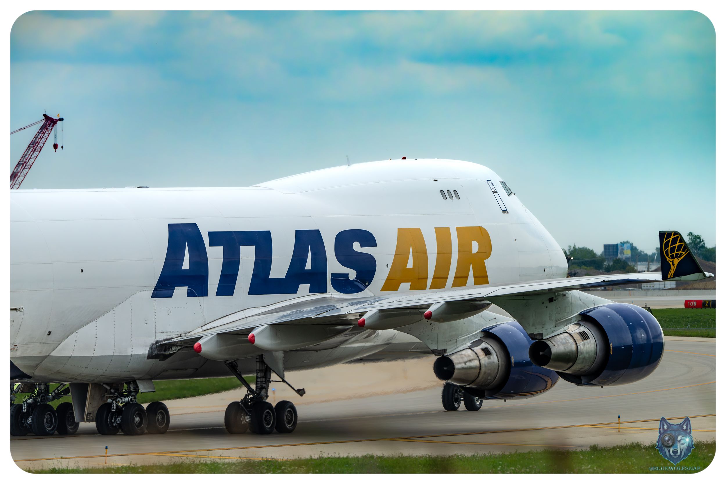 Atlas Air Boeing 747 cargo aircraft taxiing on runway, showcasing bold blue and yellow branding on white fuselage.