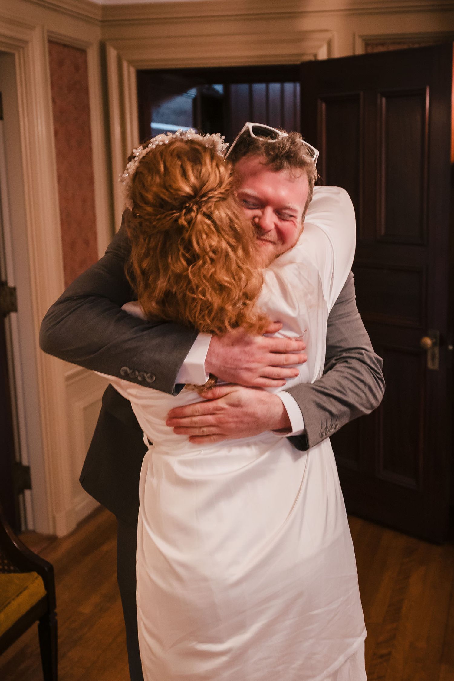 Bride in her wedding dress embracing a loved one during getting-ready moments at Searles Castle