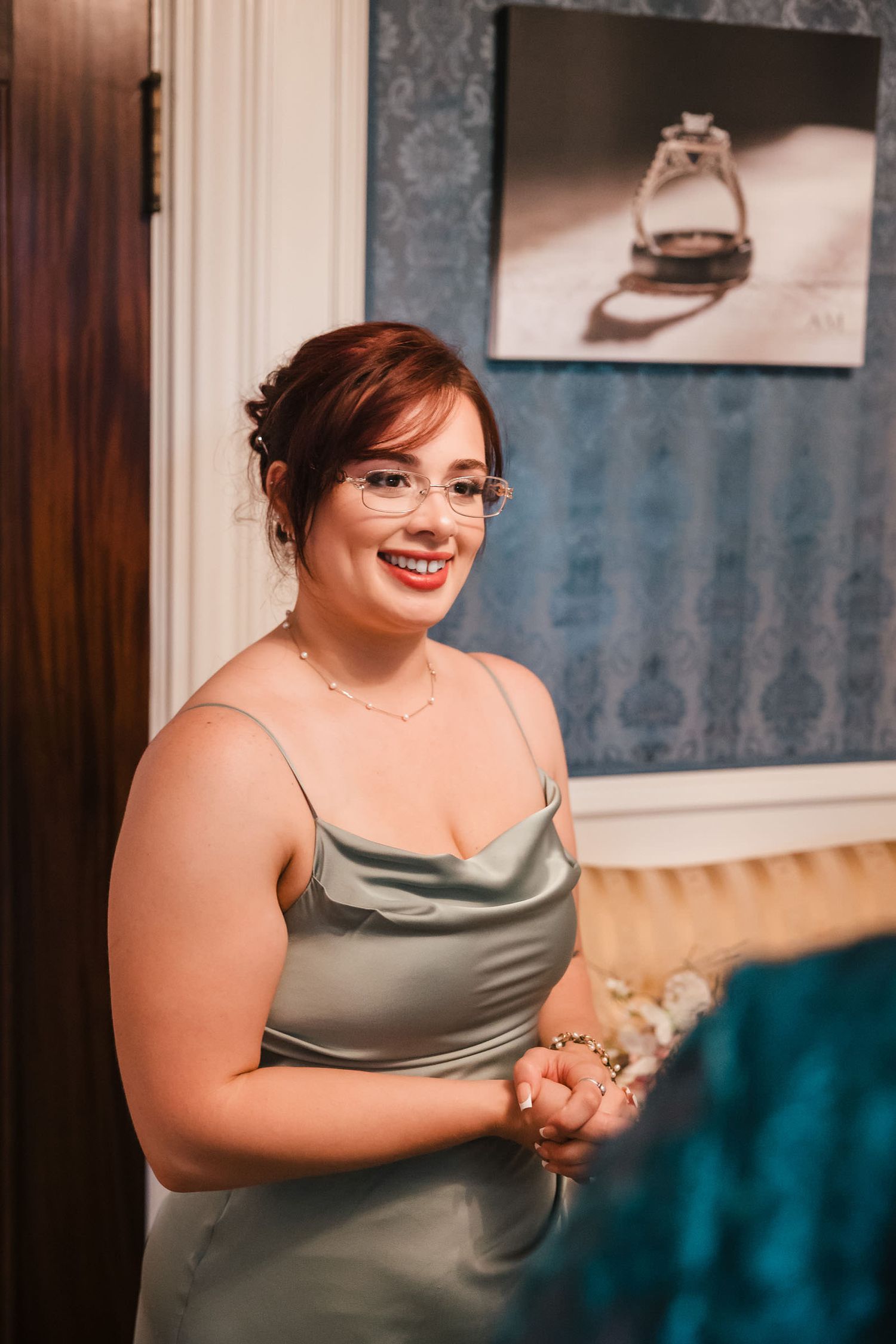 Smiling bridesmaid in a satin sage dress during bridal party preparations at Searles Castle.