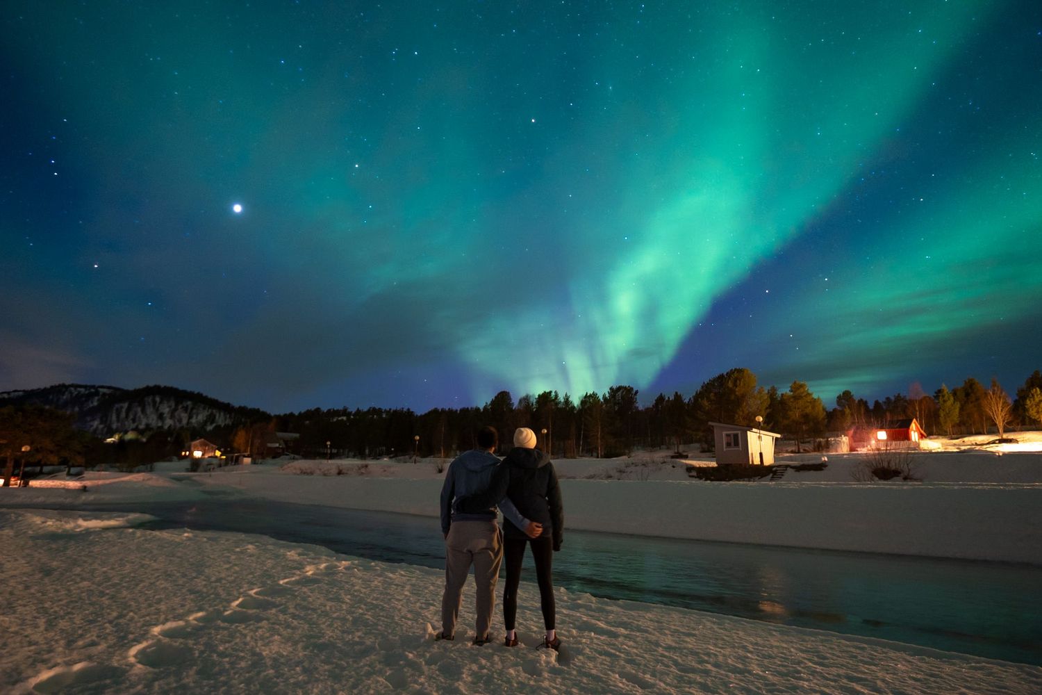 couple qui regarde les aurores boréales à senja en hiver