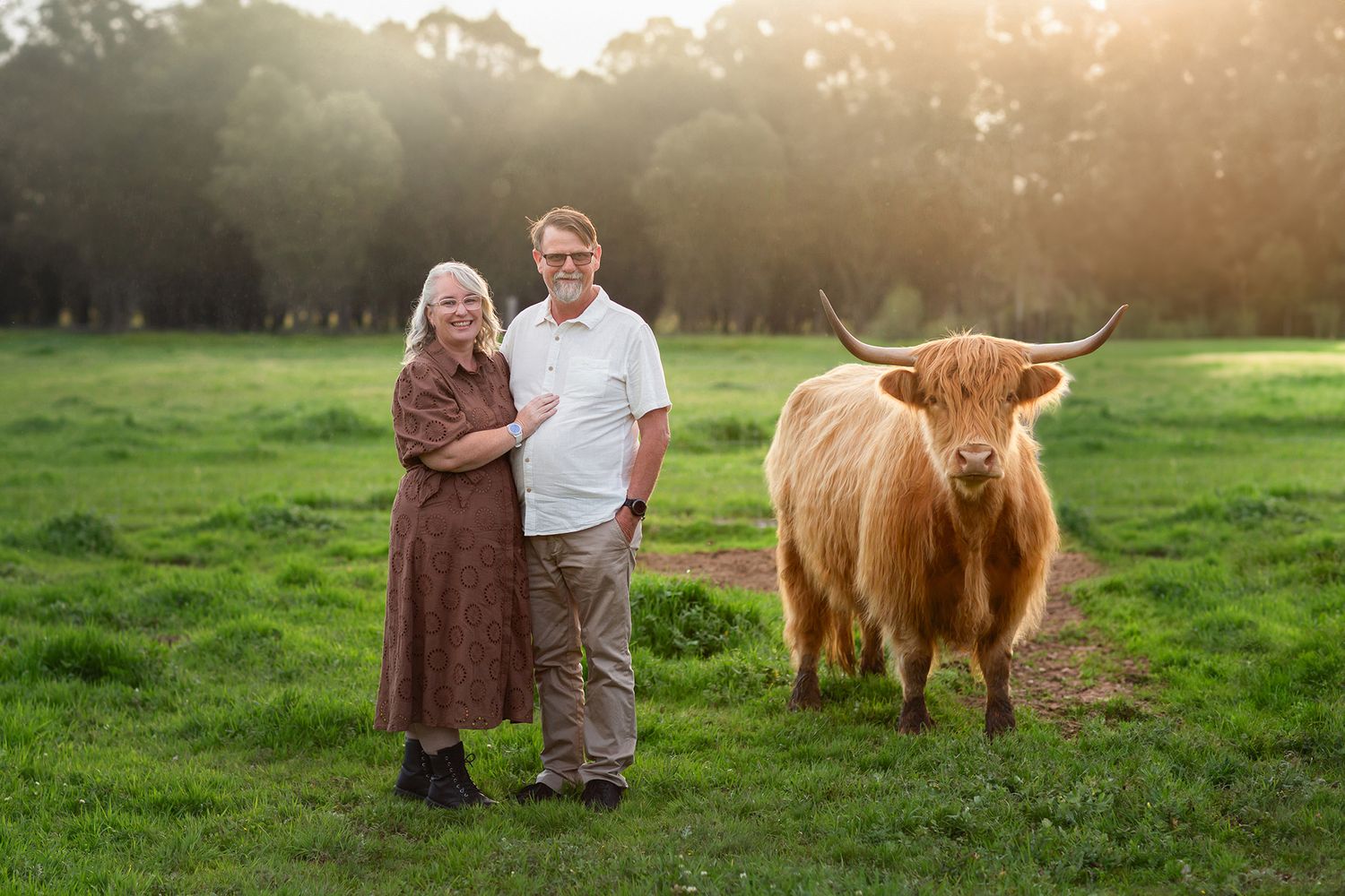 Couple with Highland Cow during a Meet the Highlands photography experience in Perth