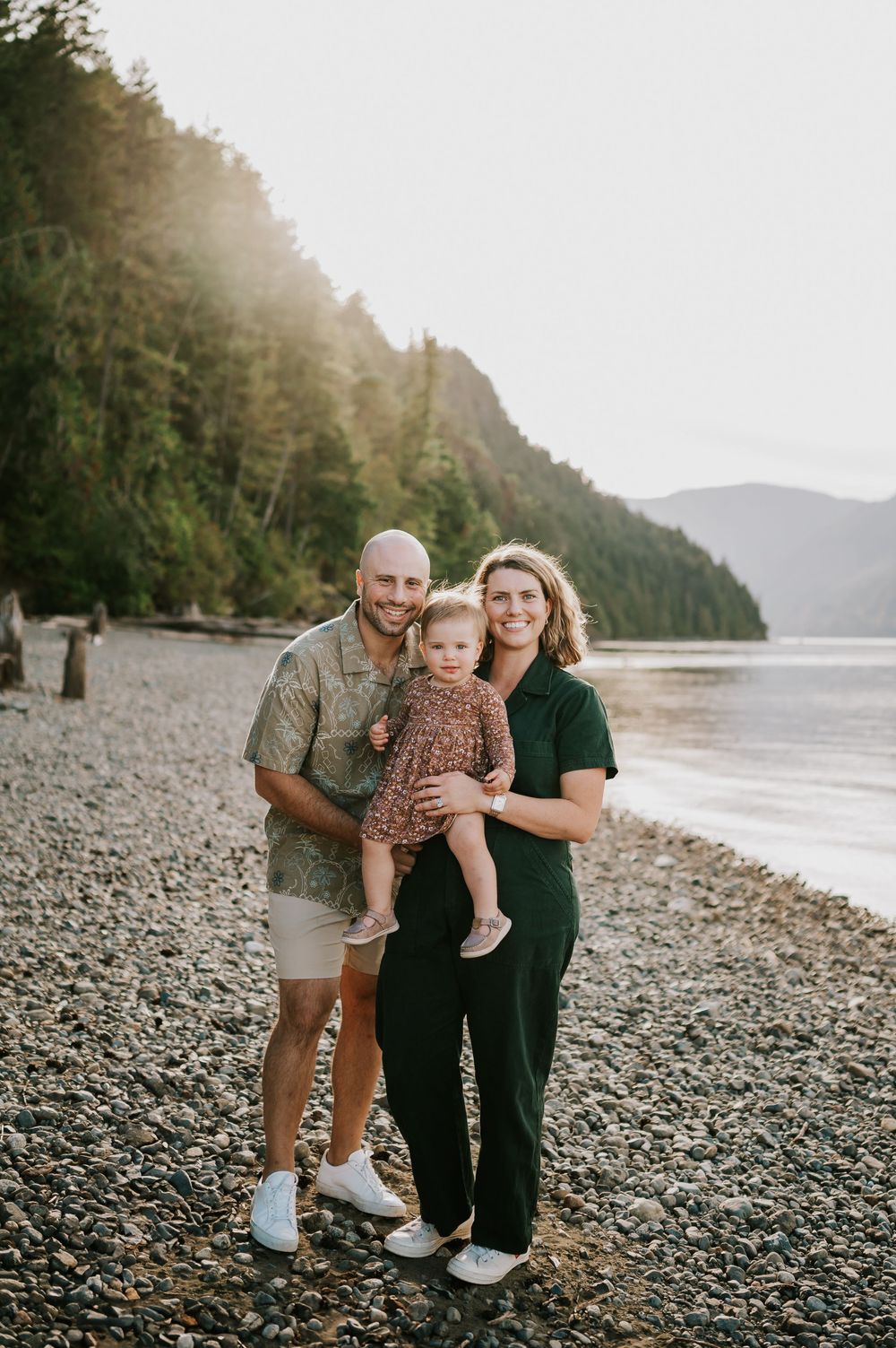 Comox Valley Photographer Portraits at Comox Lake in Cumberland, Vancouver Island. Family holding and hugging kid looking at camera