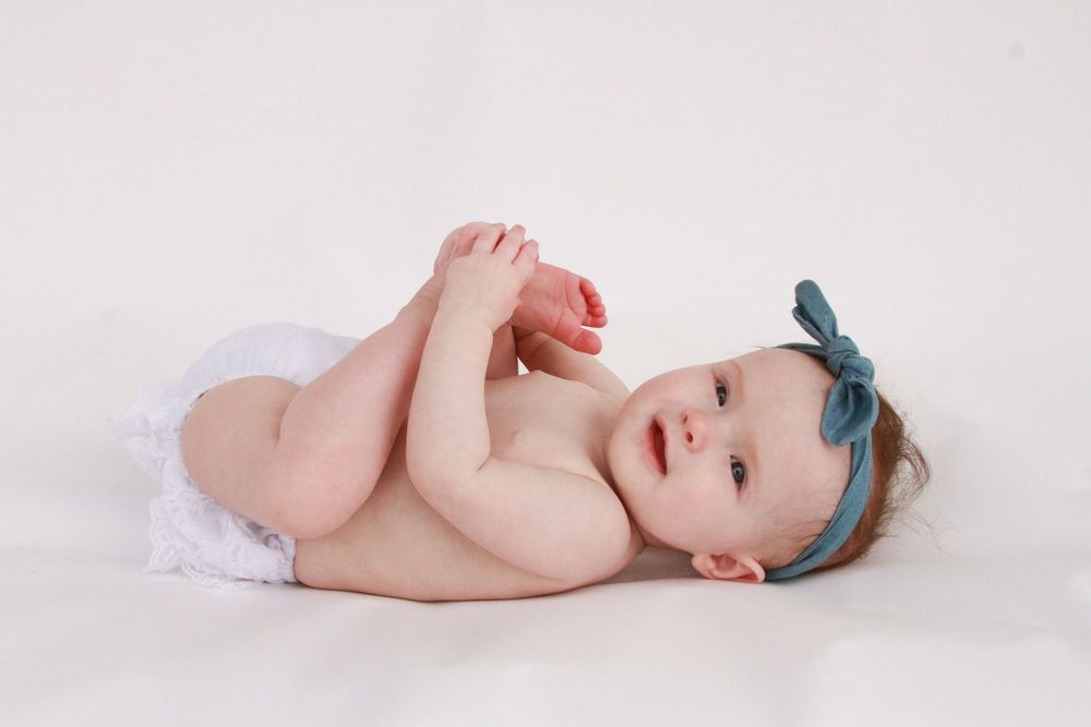Smiling infant on white background photographed by Delta Blossoms Photography