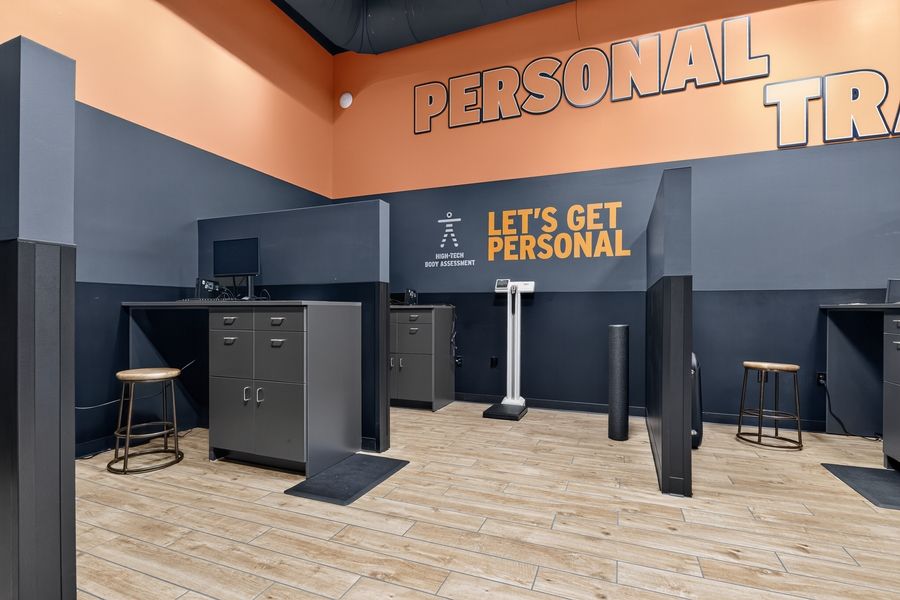 Crunch Fitness personal training area with orange accent walls and Let's Get Personal motivational signage.