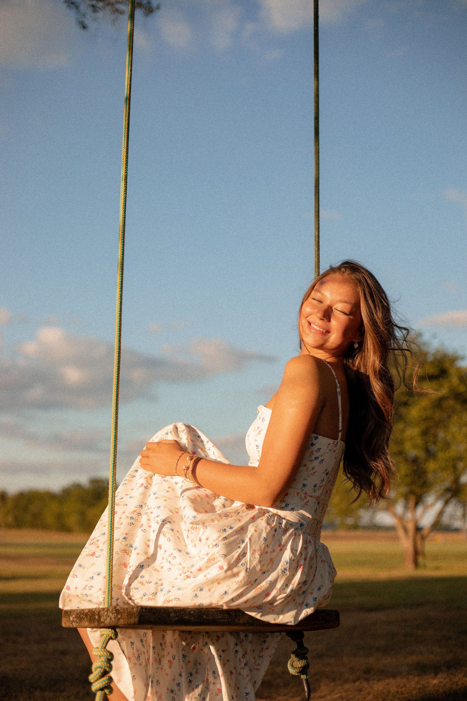 Senior portrait of high school girl holding flower during golden hour on a Kentucky farm