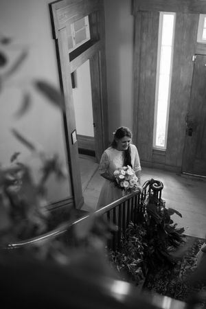 Black and white photo of flowers and light streaming through a doorway in a historic building.