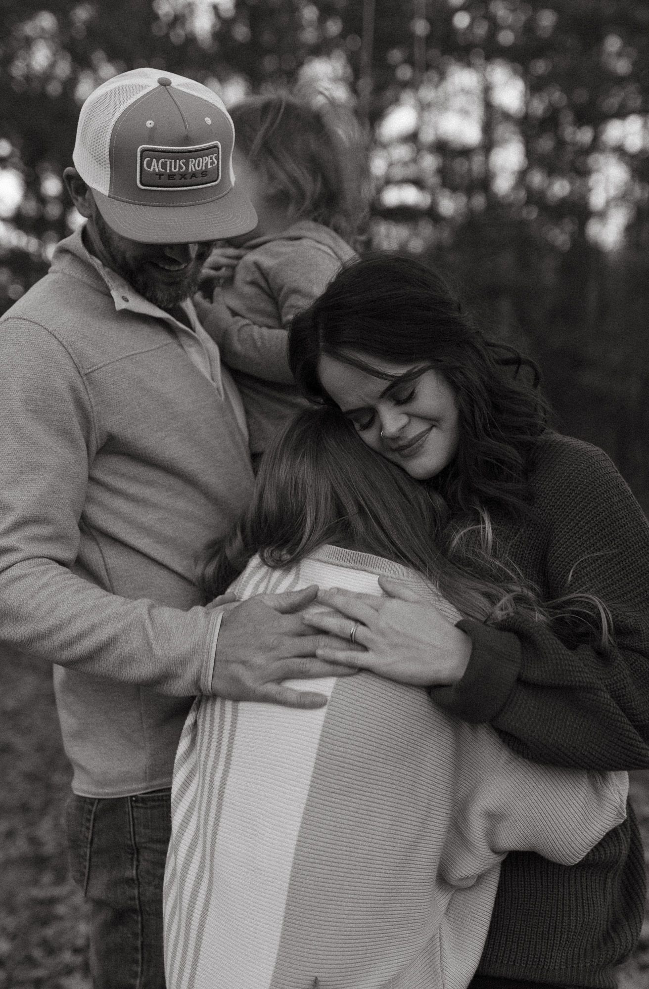 A loving family moment captured in autumn woods during golden hour.