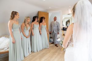 first look photo with dad and bridesmaids at Brookfield Barn wedding venue