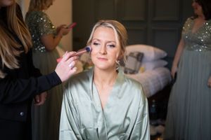 Bride having final touches done to her make up on her wedding day