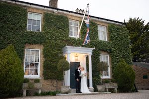 Bride and groom posing outside friern manor on their wedding day