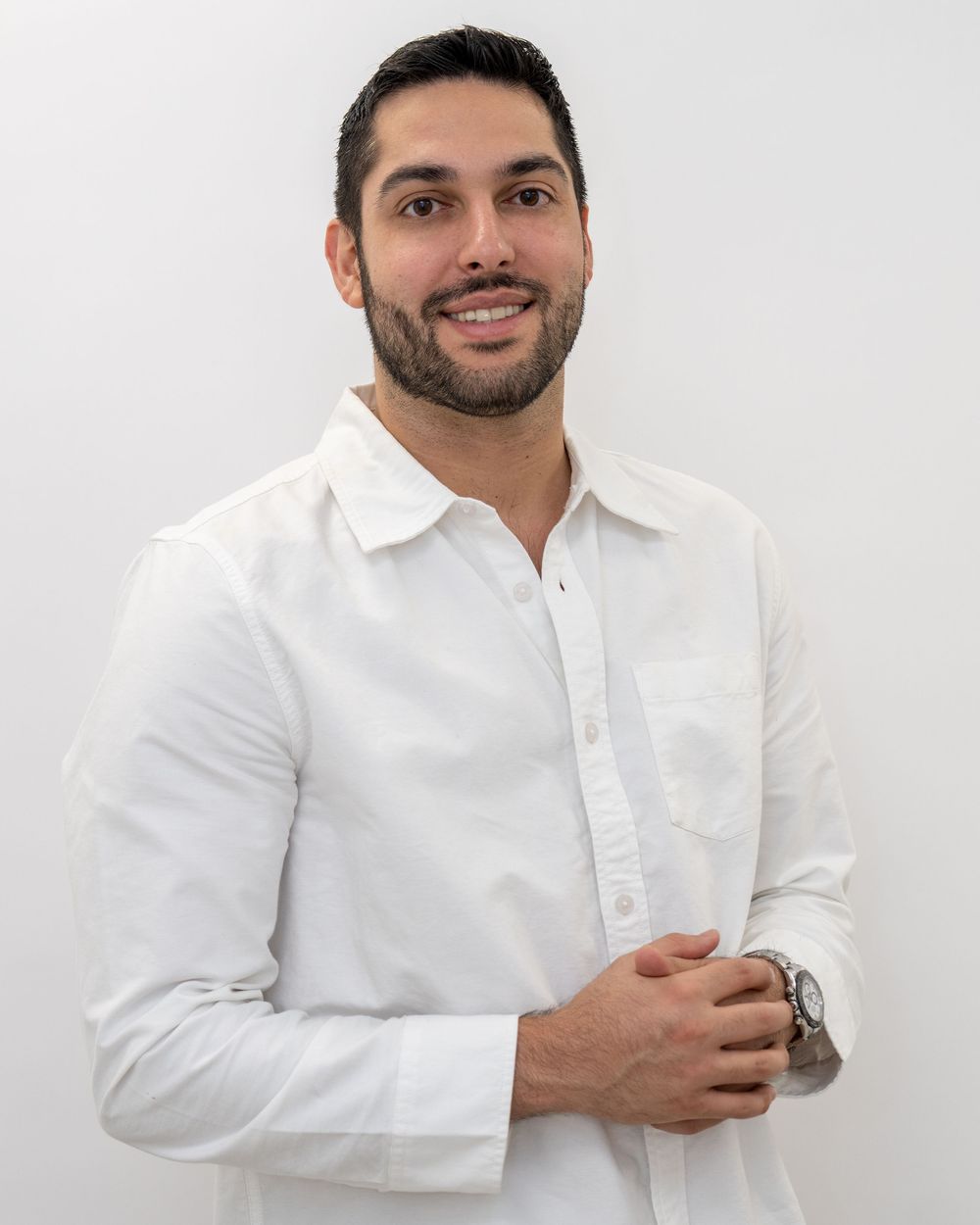 Professional headshots of person in white button-down shirt against white background.