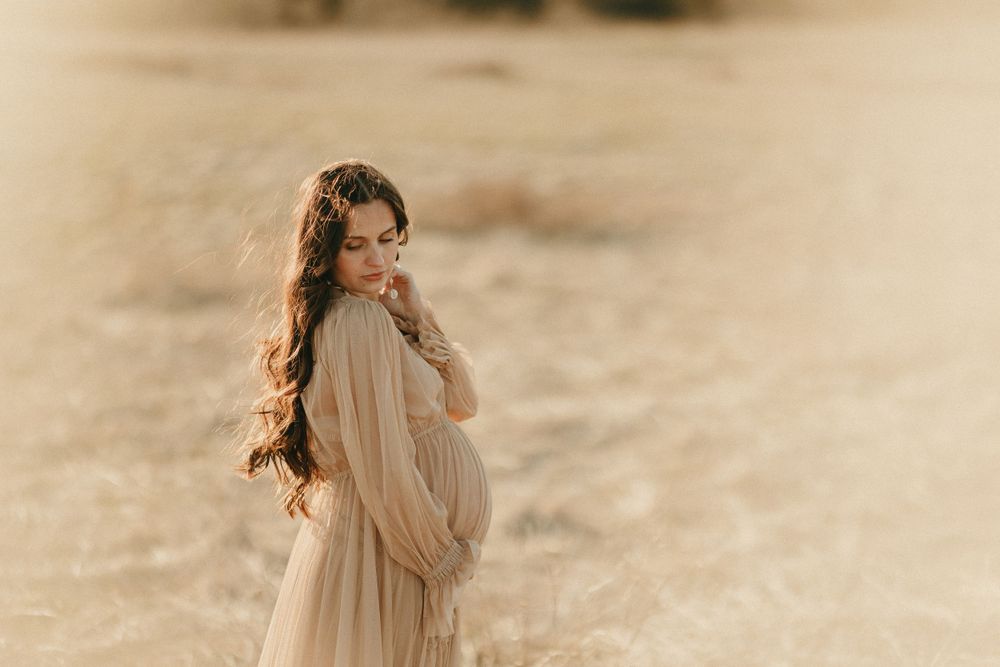 A dreamy beach photoshoot with flowing fabric and soft natural lighting.