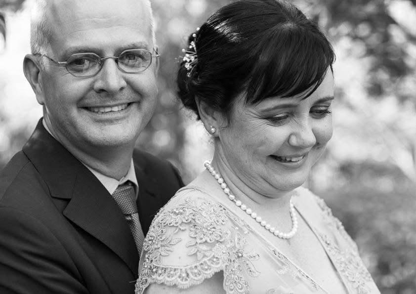 Black and white close-up portrait of smiling bride and groom on their wedding day.