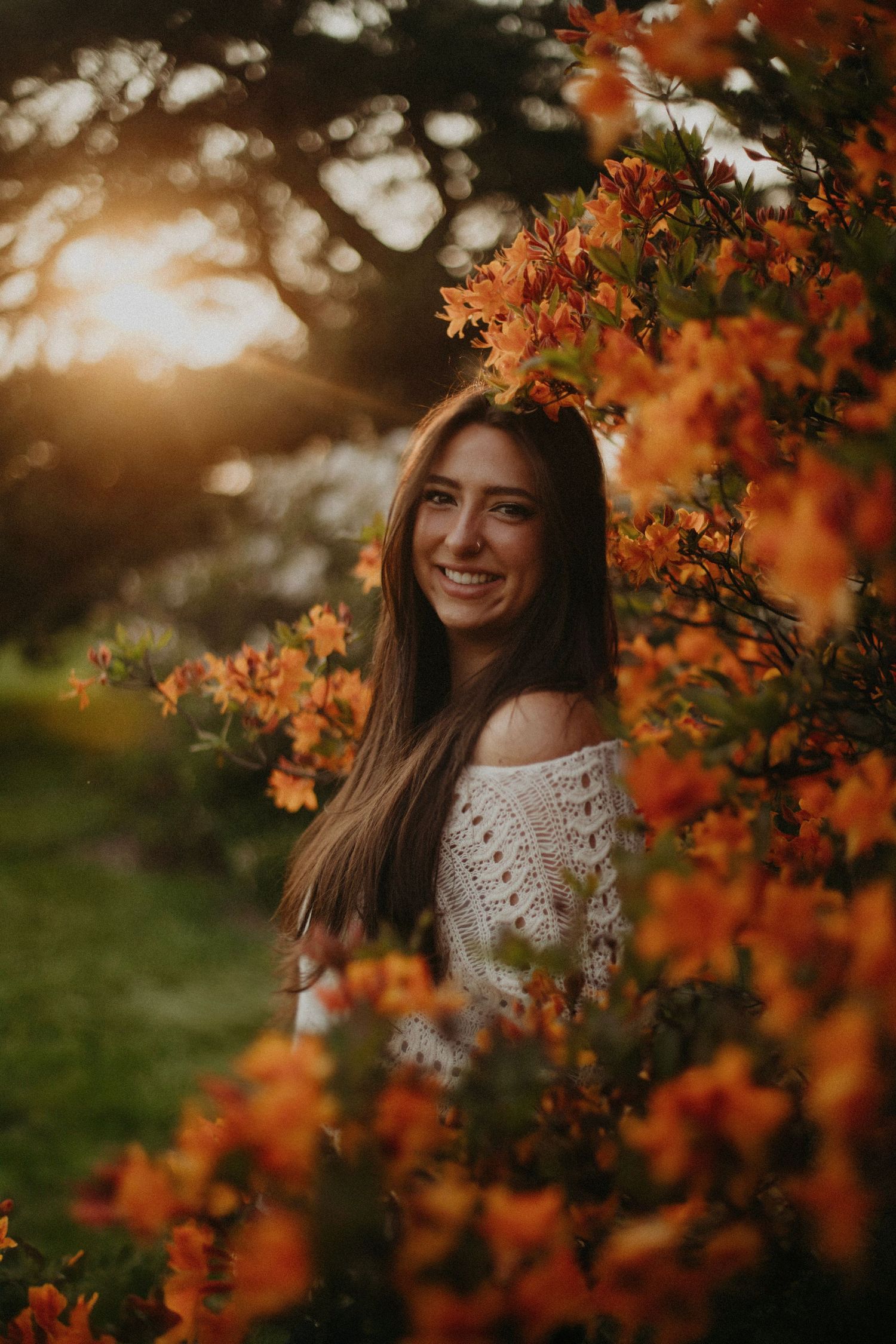 Autumn portrait with orange flowers and golden sunlight creating dreamy atmosphere.