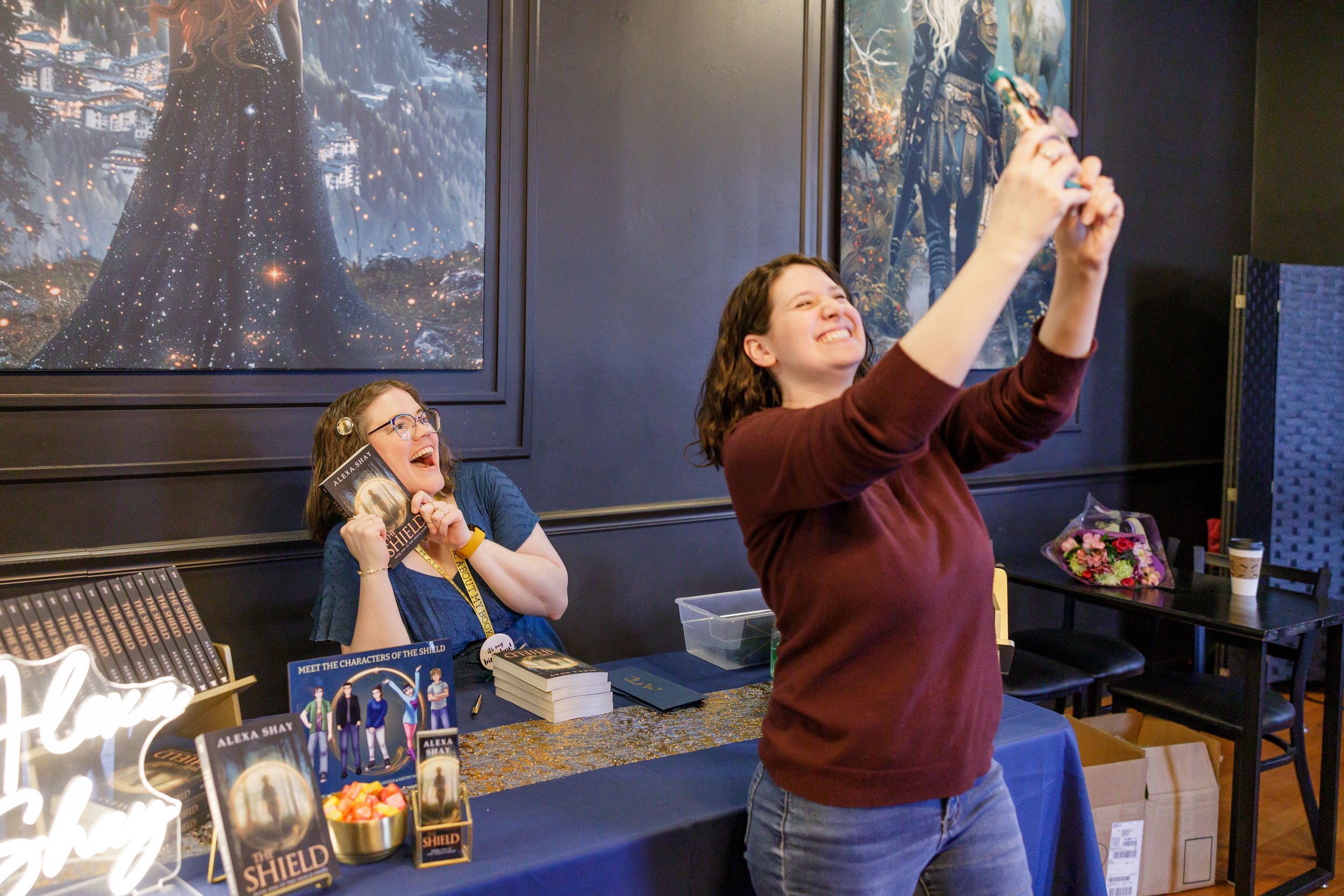 indie book author Alexa Shay author signing event in Seattle, WA bookstore reader taking selfie with author at signing table holding up book
