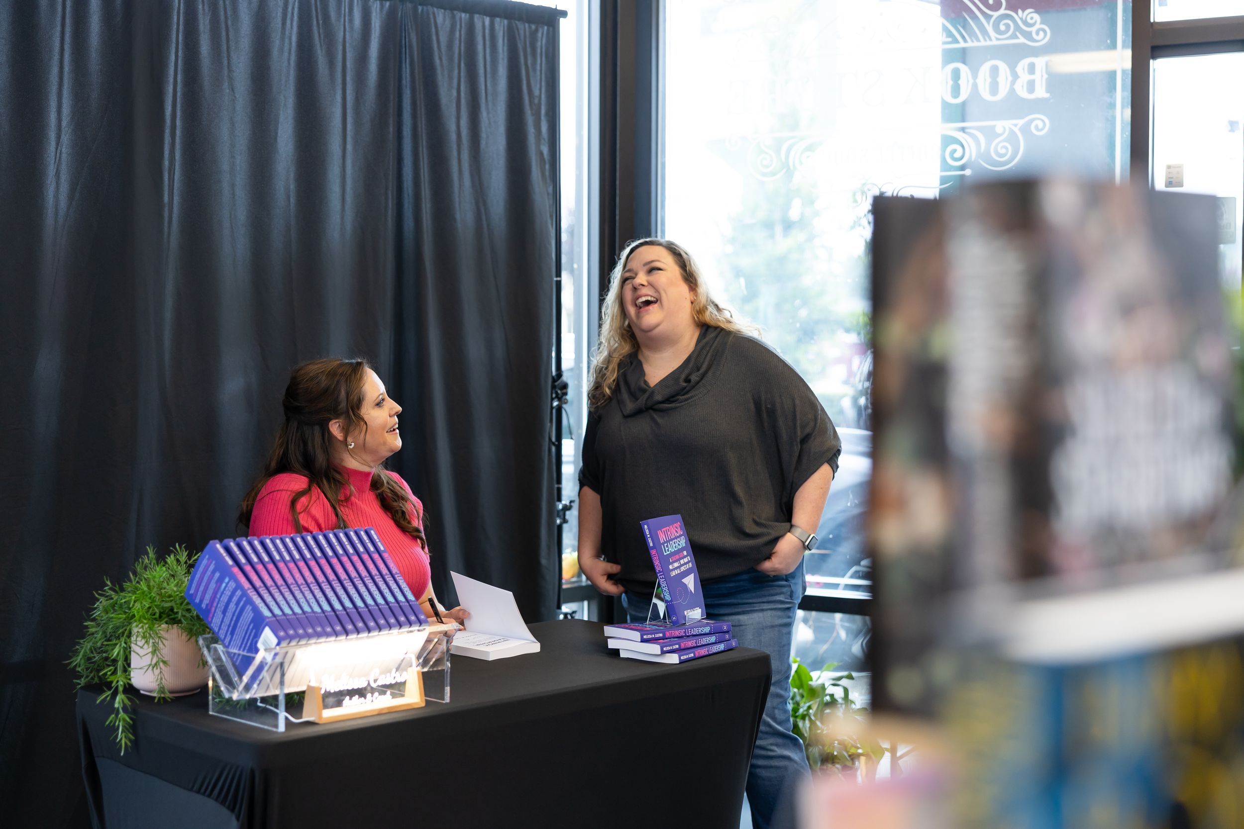 self published author Melissa Castro book signing event in Seattle, WA reader getting book signed by author laughing with her