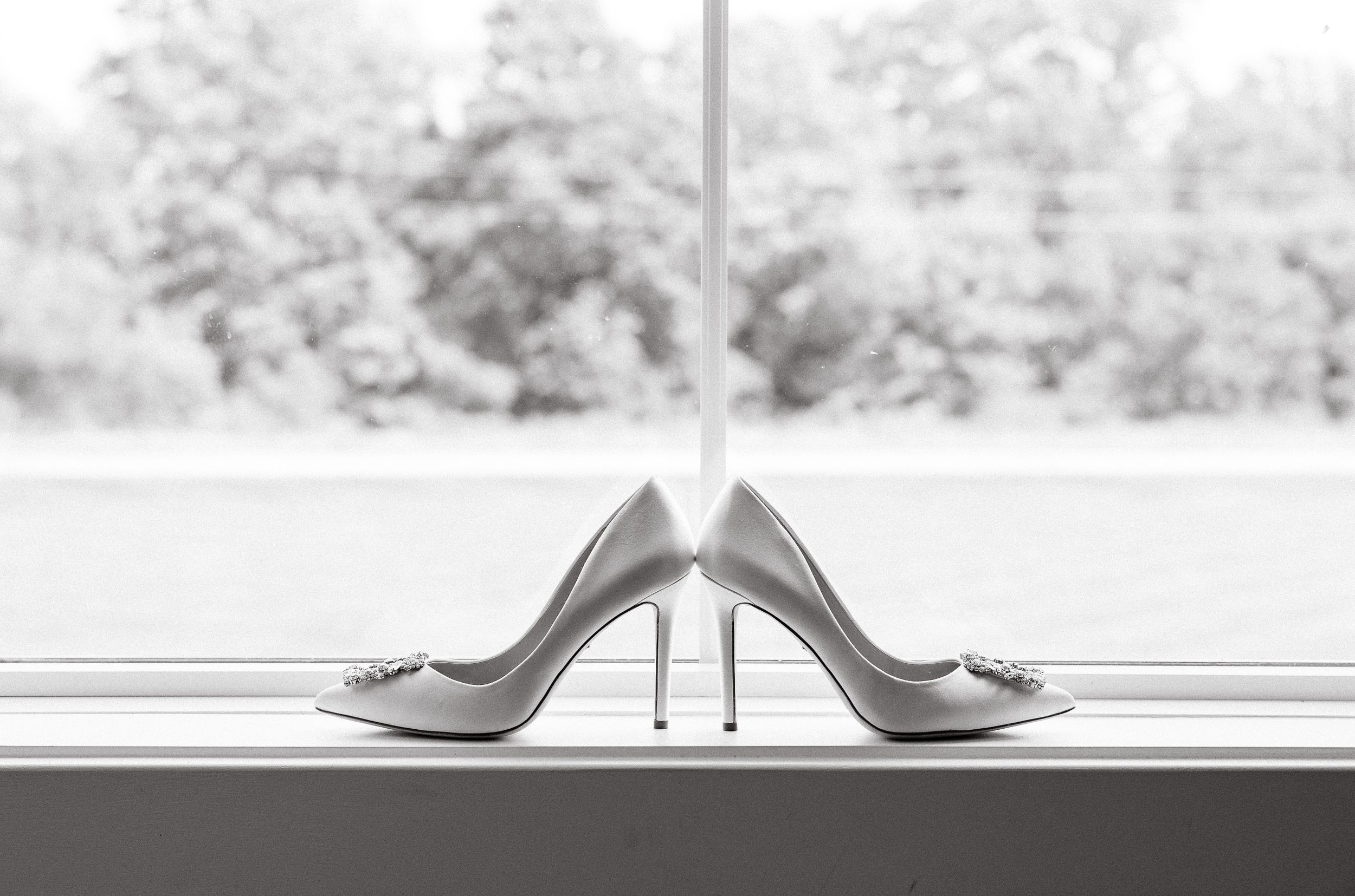 Wedding shoes displayed against a soft, blurred outdoor background.