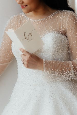 Close-up of a pearl-embellished sheer wedding dress bodice with delicate details.