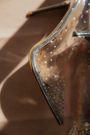 Close-up detail of sparkling crystal embellishments on a transparent surface.