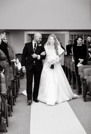 Traditional church ceremony with white wedding dress flowing down the aisle.