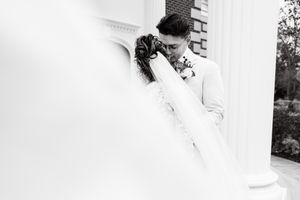 Elegant wedding dress details with flowing white fabric against a light background.