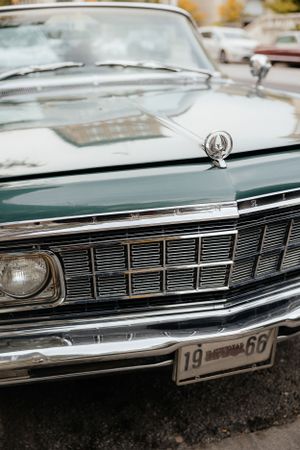 Classic chrome grille and front end detail of vintage car with retro license plate.