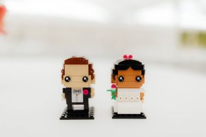 Cute cartoon-style bride and groom cake toppers in miniature form.
