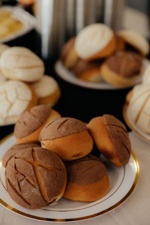 Chocolate and plain dinner rolls arranged on elegant plates for a formal event.