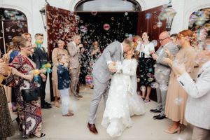 Wedding guests celebrate on the dance floor with confetti and joyful dancing at a reception.