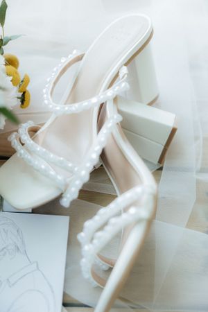 White bridal shoes arranged artistically with delicate floral accents.