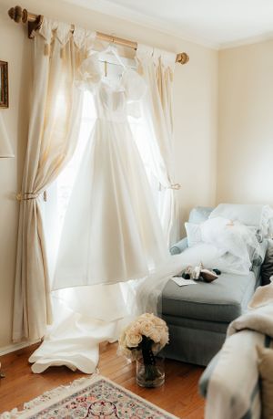 Elegant room with flowing white curtains, hardwood floors and vintage furniture.