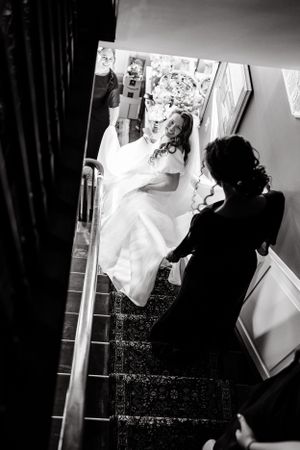 Dramatic black and white photograph of wedding dress preparation.