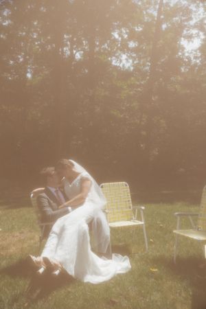 Dreamy outdoor wedding photo with flowing white dress in golden sunlight.