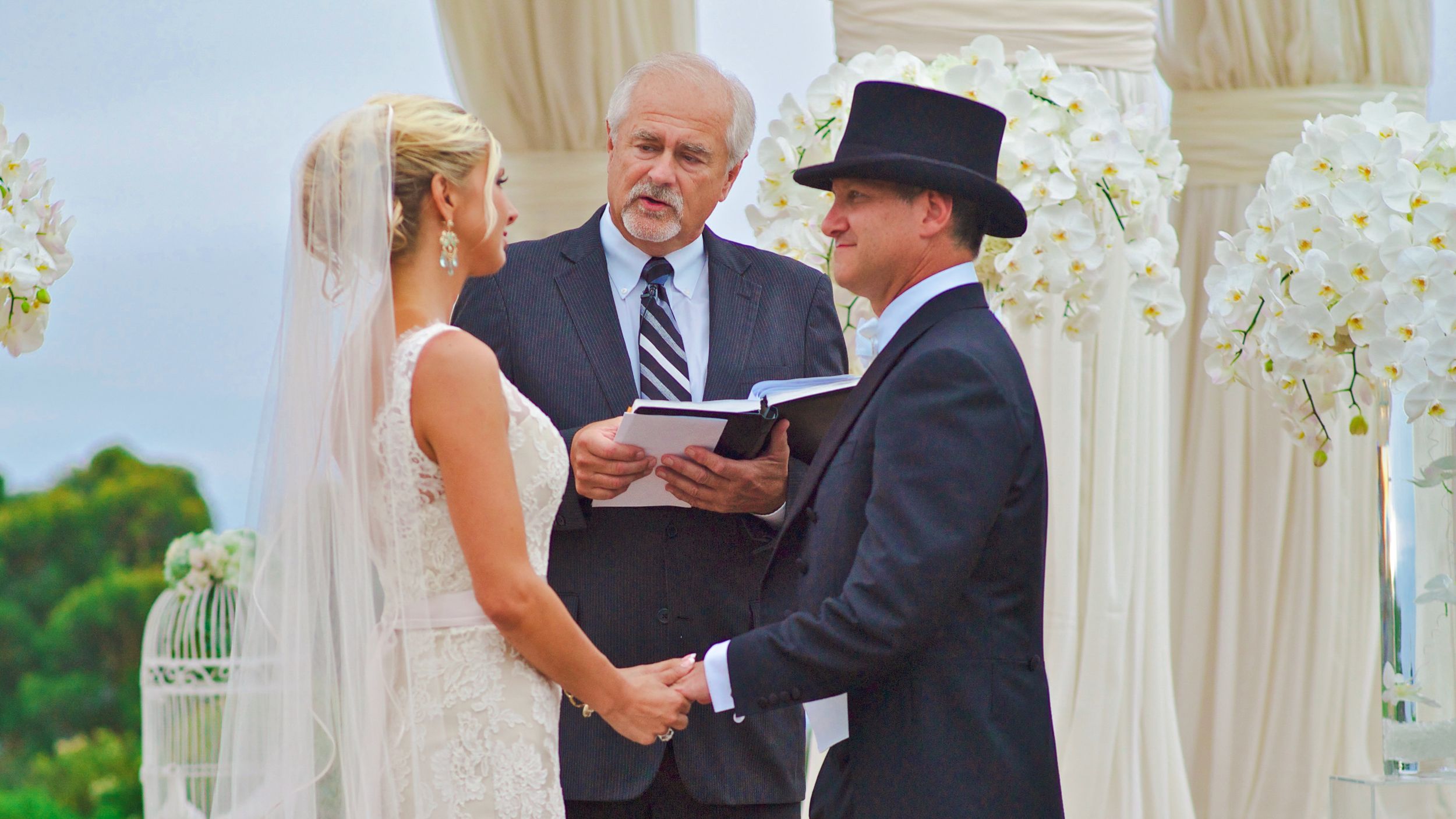 Romantic and formal outdoor wedding ceremony under a white gazebo during the service at Pellican Hill in Newport, CA.