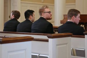 Boys will be boys even when wearing their black suits and sitting in white wooden church pews during a wedding service in Dallas, Texas.