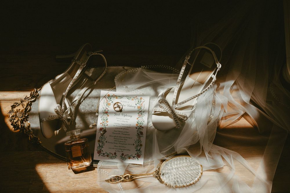 A collection of vintage antique maps and letters are arranged with spectacles and other items in low light.