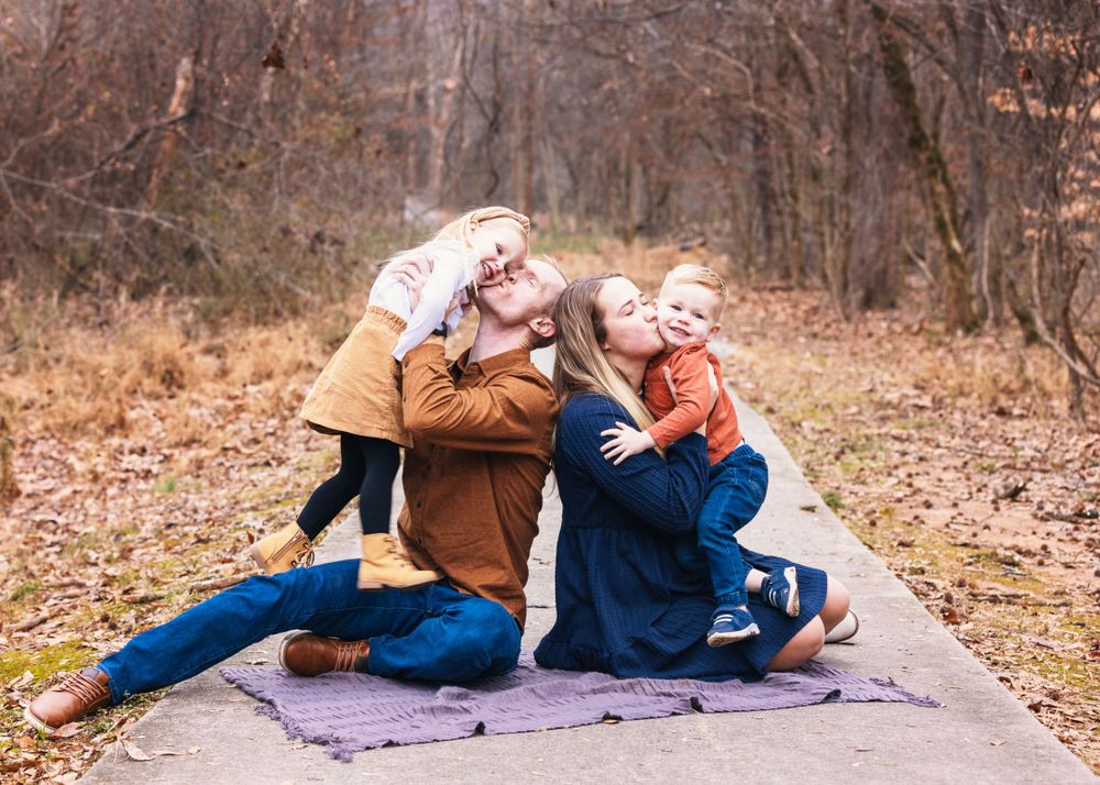 Playful family moment captured on a path during autumn.