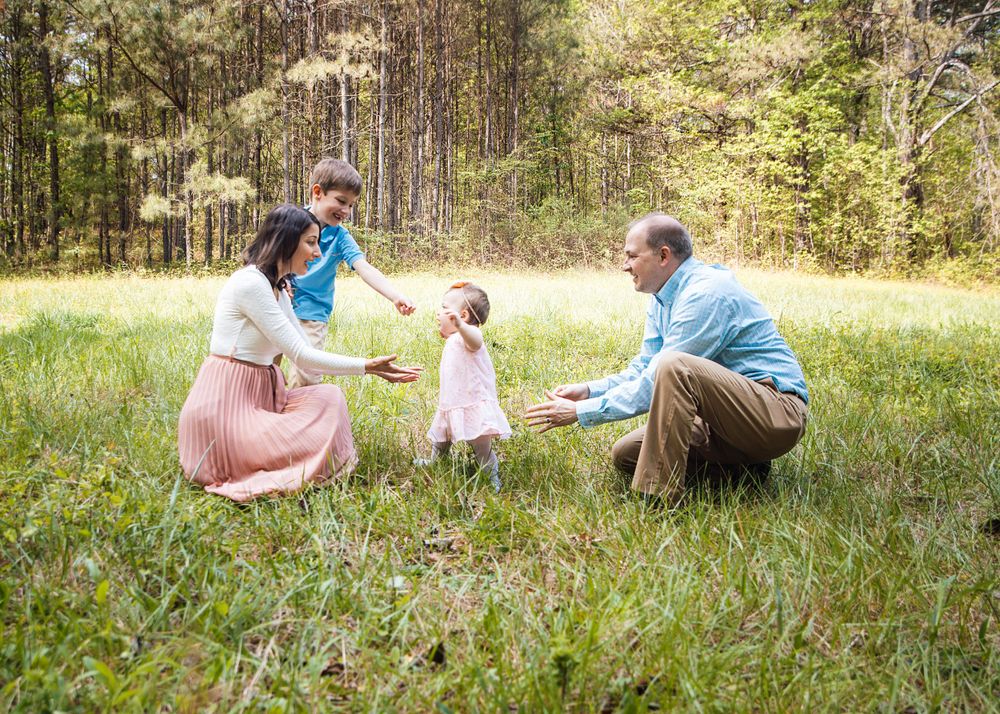 Happy moment captured in a grassy field during a family photo session.