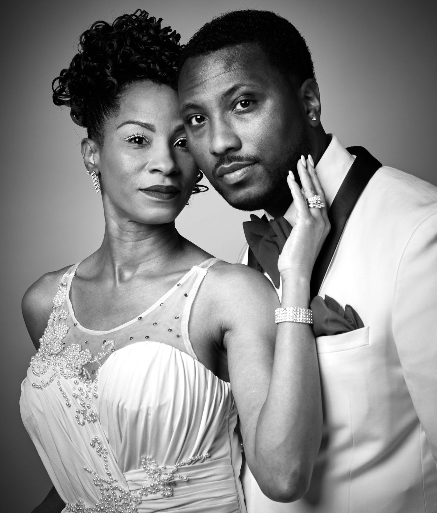 Black and white artistic portrait series showing two people in white formal attire.