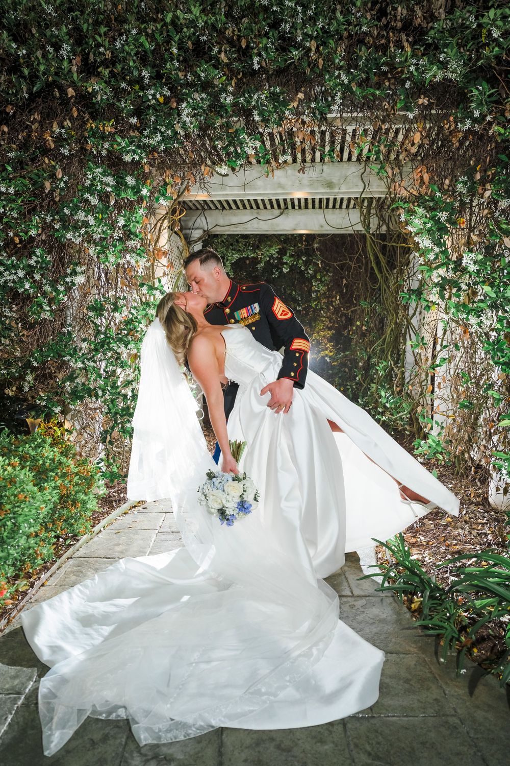 A romantic wedding couple shares tender embraces in a leafy garden pergola, captured in a series of intimate moments.